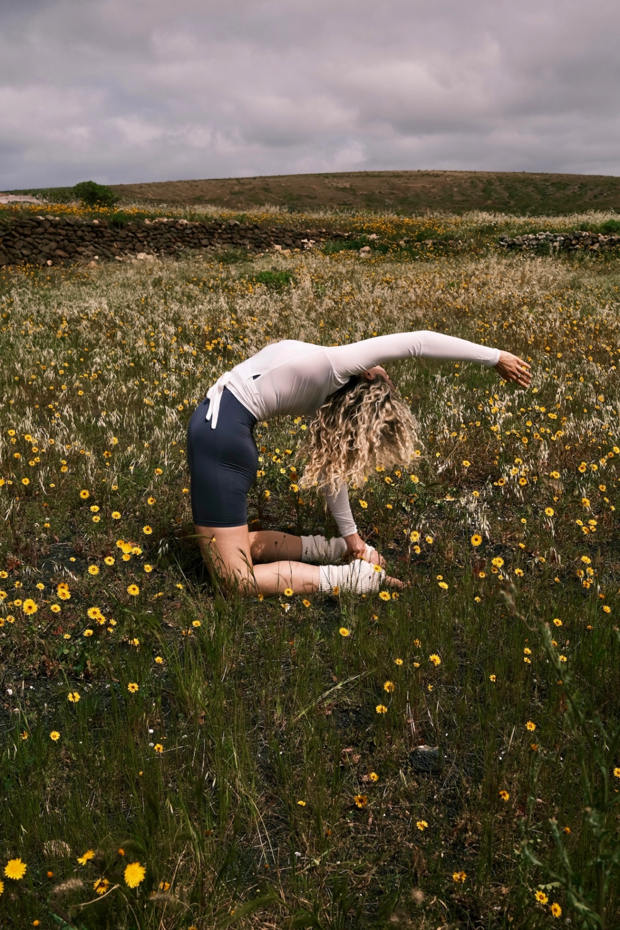 Yoga backbend in a wildflower meadow